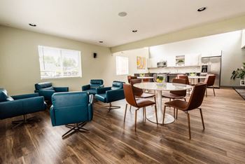 a living room with a table and chairs and a kitchen